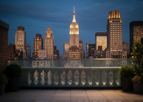 Manhattan skyline seen from a rooftop terrace with illuminated towers under an indigo evening sky