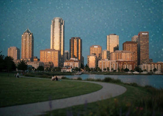 Houston downtown skyline at dusk viewed across a green park lawn and bayou path